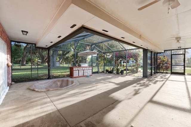 unfurnished sunroom with ceiling fan