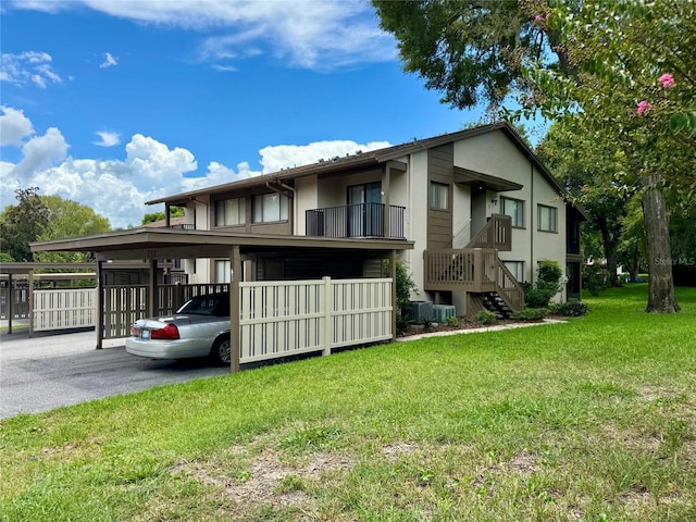 exterior space with a carport, a lawn, and central AC unit