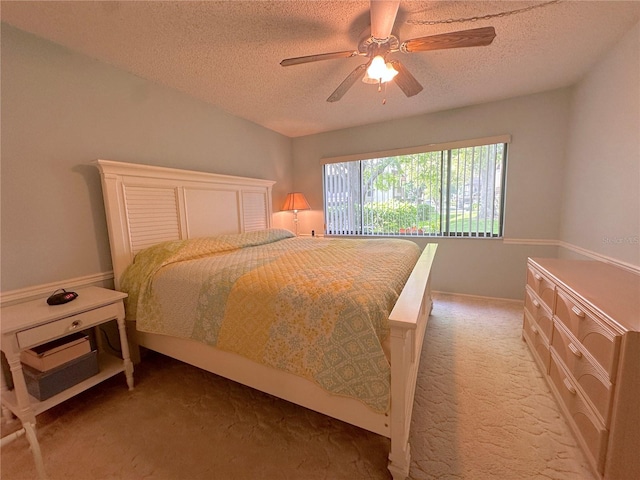 bedroom featuring ceiling fan, a textured ceiling, and carpet floors