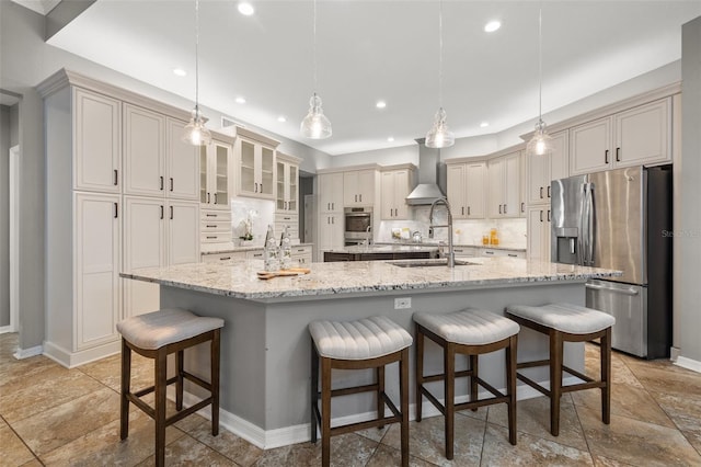 kitchen with decorative backsplash, stainless steel fridge, a breakfast bar, decorative light fixtures, and a large island