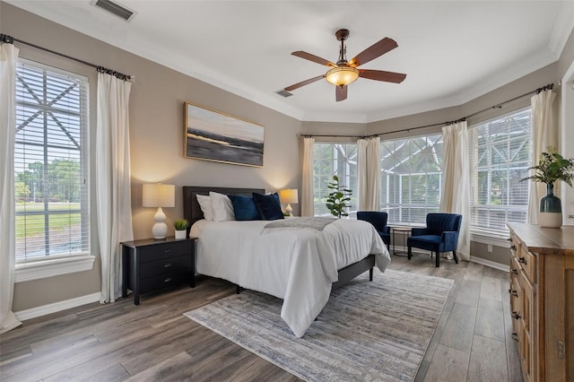 bedroom with multiple windows, ceiling fan, and light hardwood / wood-style flooring