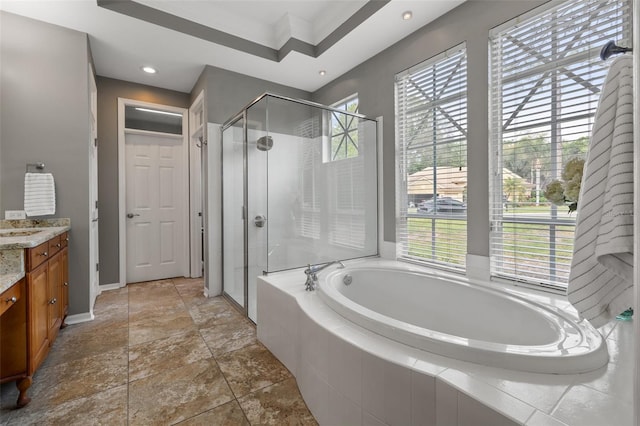 bathroom featuring vanity, a healthy amount of sunlight, and separate shower and tub