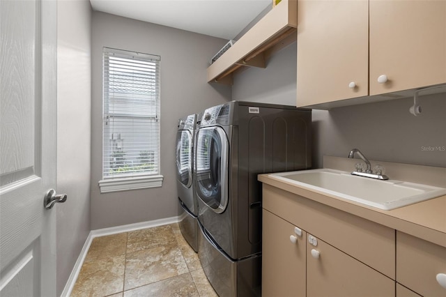 laundry room featuring cabinets, washing machine and dryer, and sink