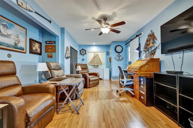 office area with ceiling fan, light wood-type flooring, and a barn door