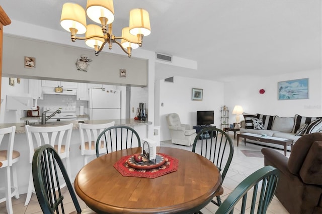 dining room featuring a notable chandelier and light tile floors