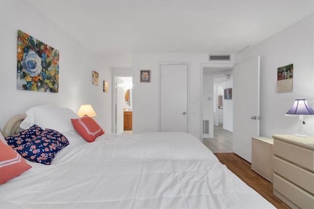 bedroom featuring wood-type flooring and connected bathroom