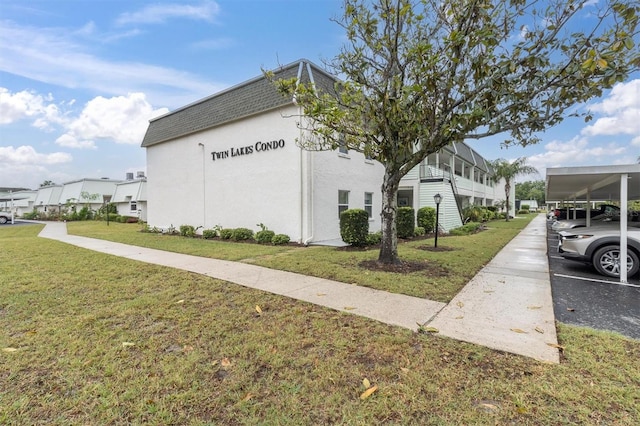 view of side of home featuring a yard and a carport