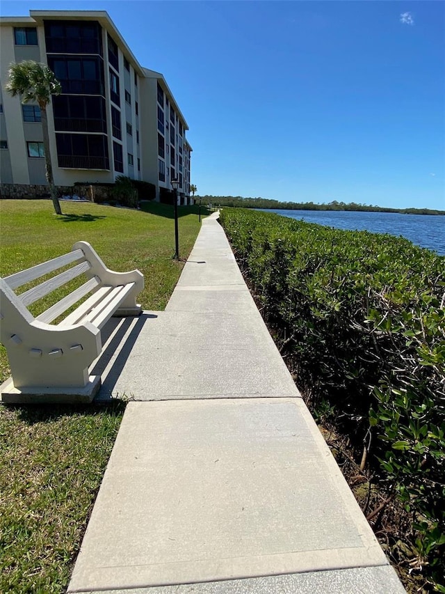 surrounding community featuring a water view and a lawn