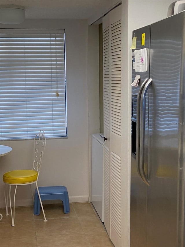 interior space with light tile flooring and washer / dryer