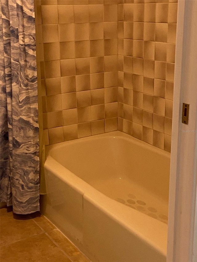 bathroom featuring shower / bath combo with shower curtain and tile flooring