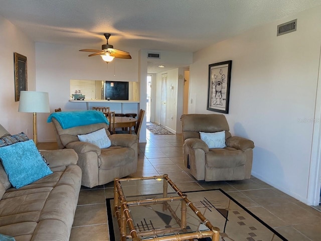 tiled living room featuring ceiling fan and a textured ceiling