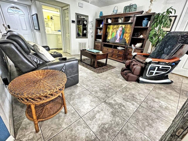 tiled living room featuring washer / dryer