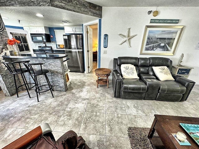 living room featuring a textured ceiling and light tile flooring