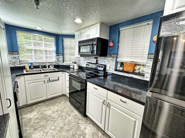 kitchen with sink, light tile flooring, tasteful backsplash, white cabinetry, and black appliances