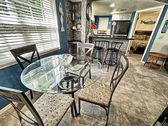 dining area with light tile floors and a textured ceiling