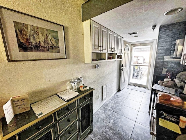 kitchen featuring light tile floors and a textured ceiling