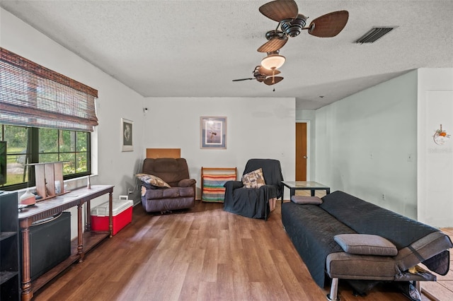 living area featuring a textured ceiling, ceiling fan, and hardwood / wood-style floors