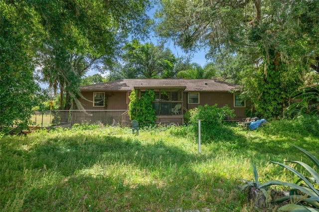 rear view of house featuring a lawn