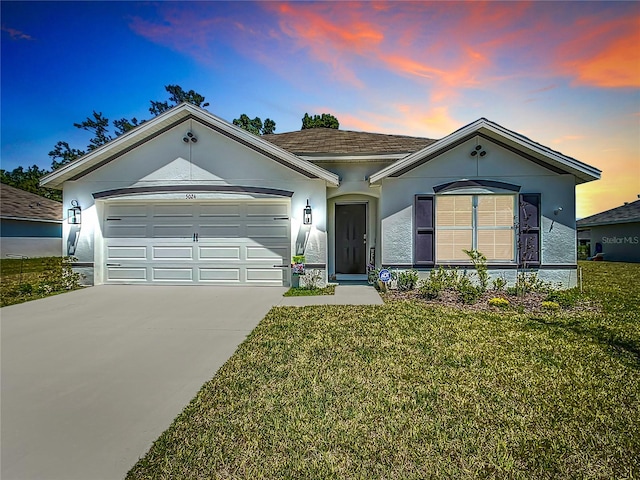 ranch-style house featuring a yard and a garage