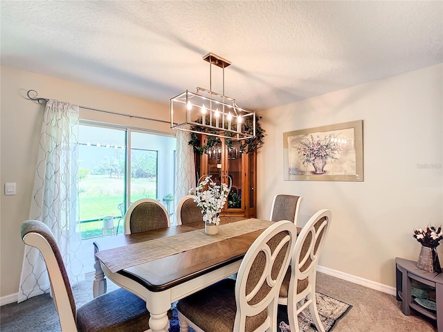 carpeted dining area featuring a textured ceiling and an inviting chandelier