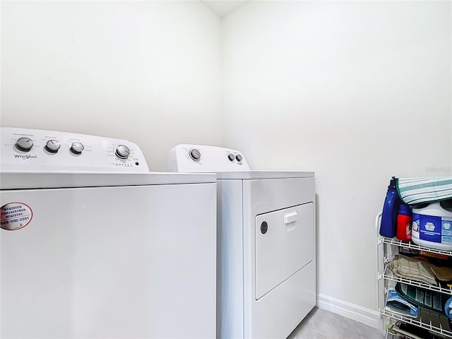 washroom featuring light tile floors and washer and clothes dryer