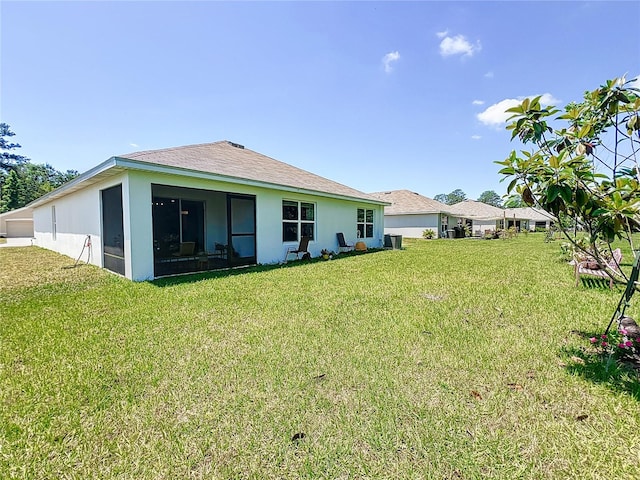 back of house with a sunroom and a lawn