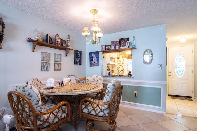 dining area with a notable chandelier, tile flooring, and a textured ceiling