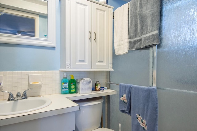 bathroom with tasteful backsplash, toilet, and large vanity