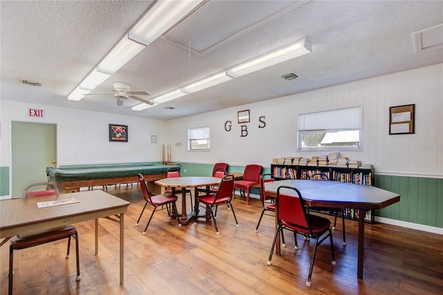 dining space with ceiling fan, hardwood / wood-style floors, a textured ceiling, and billiards