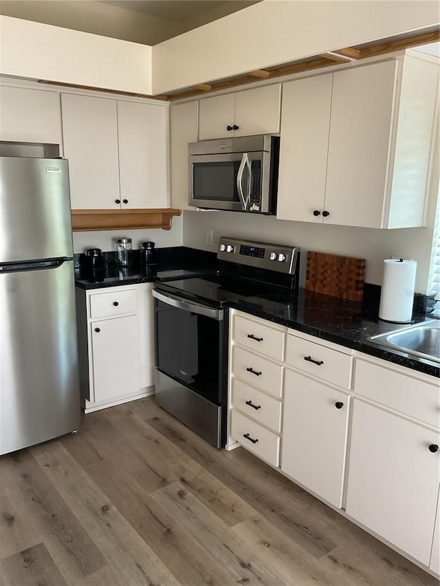 kitchen featuring appliances with stainless steel finishes, dark hardwood / wood-style flooring, and white cabinetry