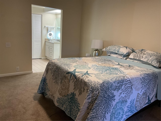 bedroom with sink, light carpet, and connected bathroom