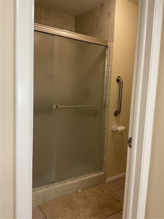 bathroom featuring tile patterned floors and a shower with door