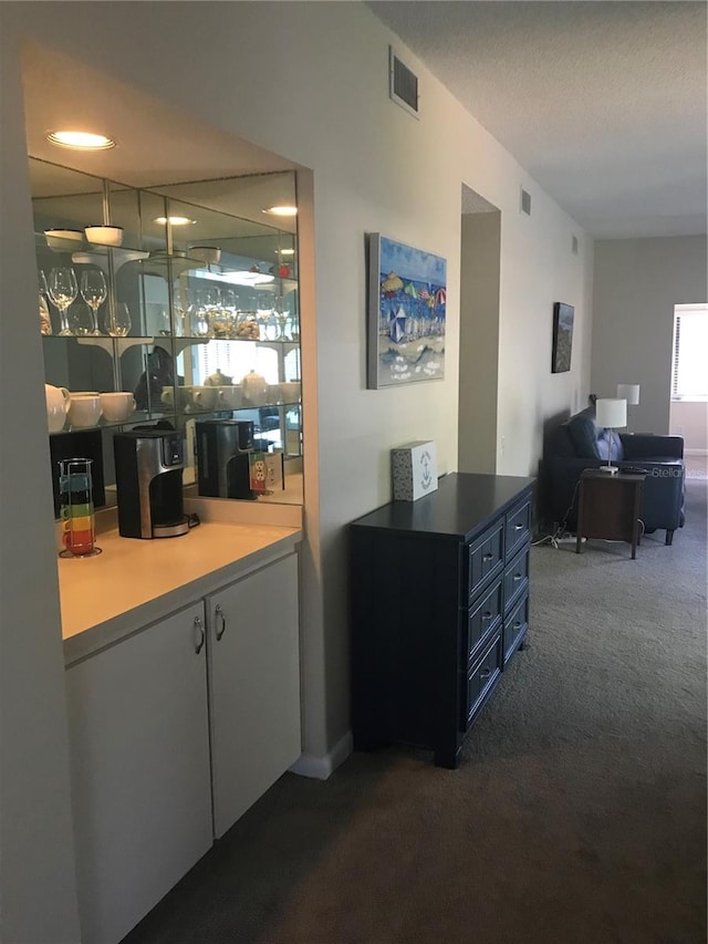 bar with carpet, blue cabinets, and white cabinets