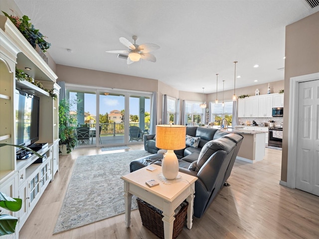 living room with ceiling fan and light wood-type flooring