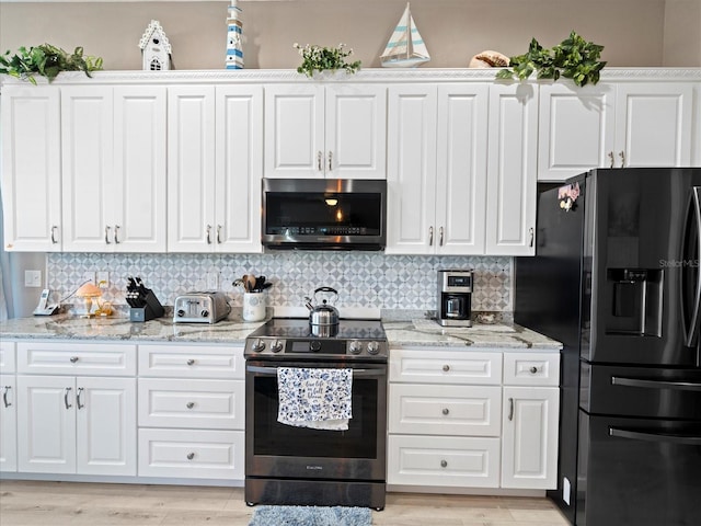 kitchen featuring electric range oven, white cabinetry, black refrigerator with ice dispenser, tasteful backsplash, and light hardwood / wood-style floors