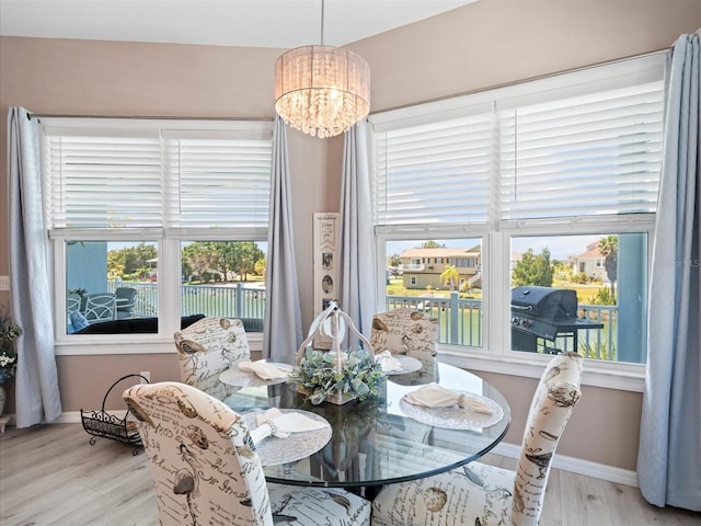 dining space featuring a notable chandelier and light wood-type flooring