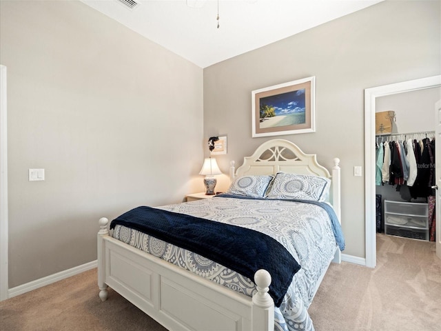 carpeted bedroom featuring a closet and a walk in closet