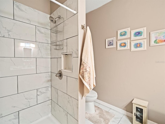 bathroom with tile floors, toilet, and a tile shower