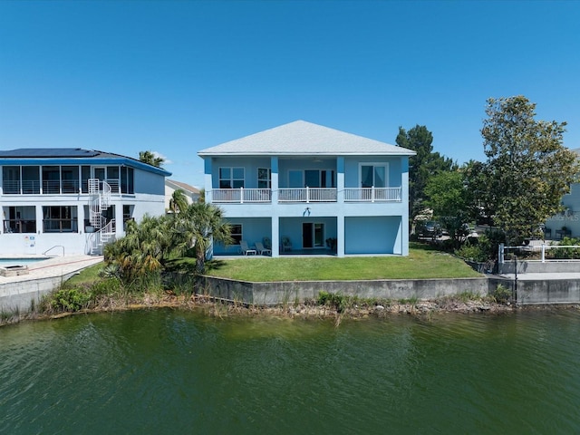 rear view of property with a patio area, a water view, a balcony, and a lawn