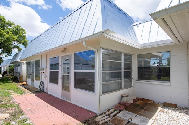 view of side of property with a patio and a sunroom