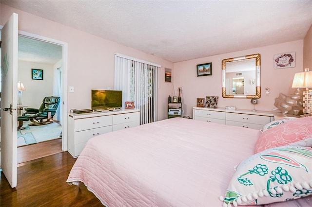 bedroom featuring a textured ceiling and dark wood-type flooring