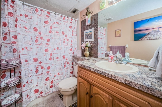 bathroom featuring a textured ceiling, vanity with extensive cabinet space, toilet, and tile flooring