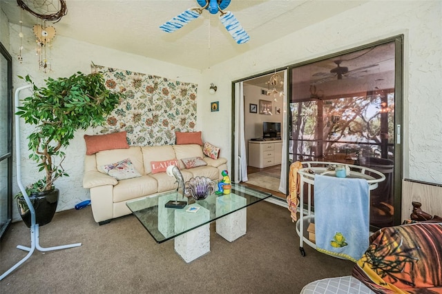 living room featuring carpet, ceiling fan, and a textured ceiling