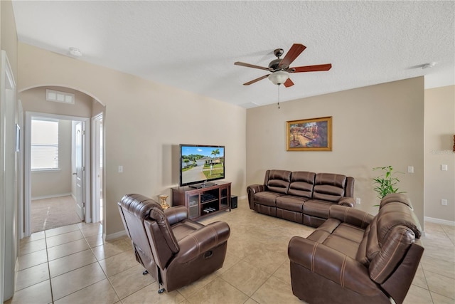 living room with light colored carpet, ceiling fan, and a textured ceiling