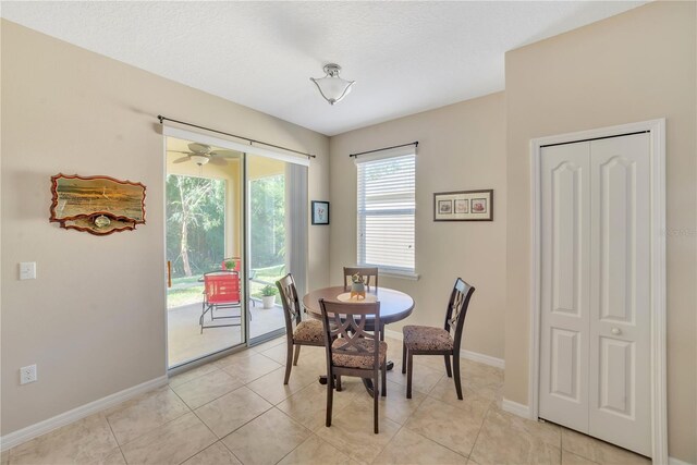 dining area with ceiling fan and light tile flooring