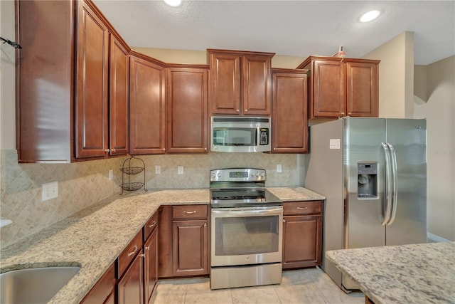 kitchen with backsplash, stainless steel appliances, and light tile floors