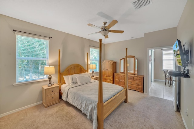 bedroom with light colored carpet, ceiling fan, and multiple windows