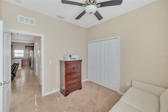 living area with ceiling fan and light tile floors