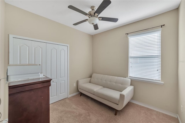 sitting room featuring light colored carpet and ceiling fan