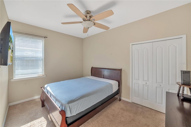 carpeted bedroom featuring a closet, multiple windows, and ceiling fan